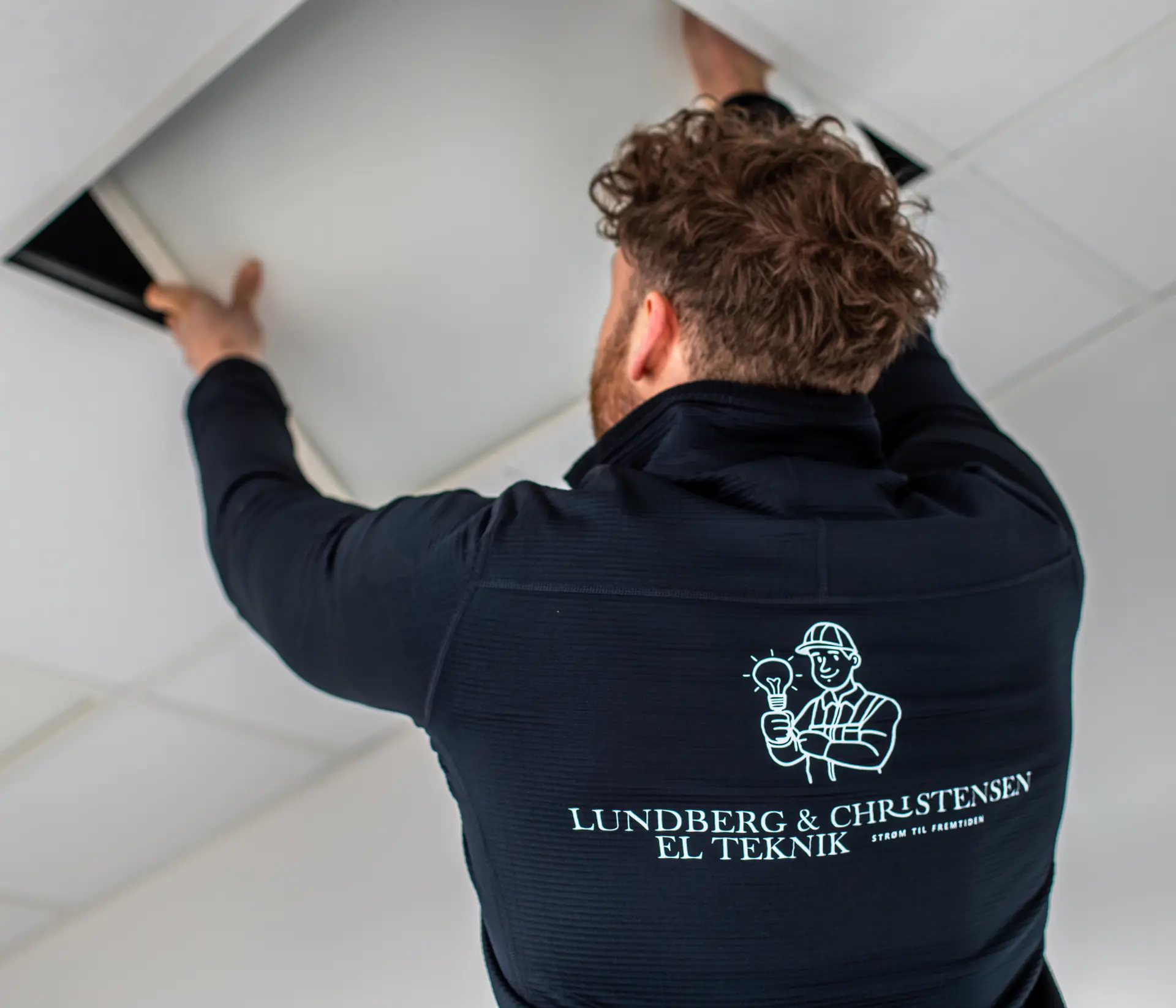 Elektriker monterer LED-loftpanel, Lundberg & Christensen belysning København